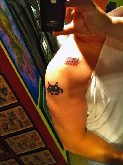 Arm tattoo of a 6502 chip and a Space Invader squid