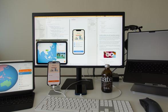 Workplace with Macbook Pro showing development work of the geotrainer app for iOS 26