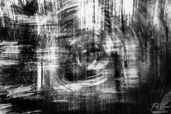 Je m'étais bien amusé ce jour là…
Photographie en noir et blanc, présentant le résultat du cumul de trois prises de vue du même sujet, un sous-bois, en pratiquant 2 fois 1 panotage vertical vers le haut en tenant l'appareil en format portrait, puis en format paysage et une rotation autour de l'axe de l'objectif pour la troisième captation.
Le résultat est relativement abstrait avec comme des rayures claires (la lumière filtrée par la ramure des arbres) horizontales et verticales et en cercles concentriques au centre du cadrage.