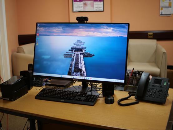 An office desktop in Mid Suffolk with monitor, keyboard and mouse, mini PC and VOIP telephone