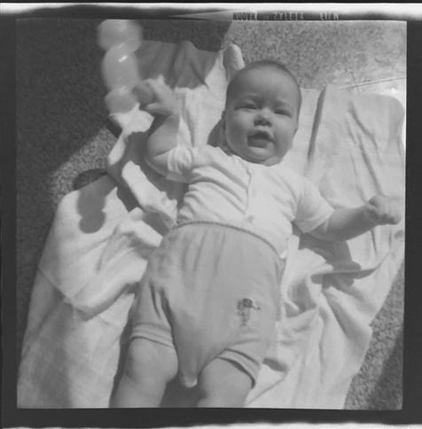 Black and white image of me as an infant, on the floor in the sun.