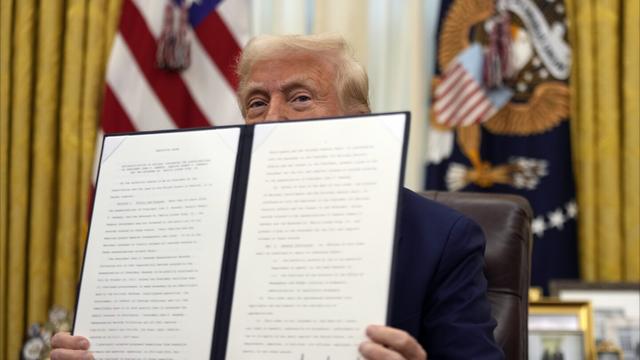 President Donald Trump holds a signed an executive order regarding the declassification and release of records relating to the assassinations of former President John F. Kennedy, Sen. Robert F. Kennedy and Rev. Martin Luther King, Jr., in the Oval Office of the White House, Thursday, Jan. 23, 2025, in Washington. (AP Photo/Ben Curtis)