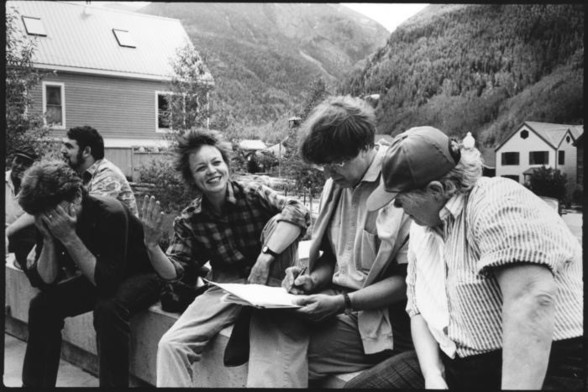 A black-and-white photo of composers (left to right) I Wayan Sadra, Larry Polansky, Jim Tenney (head in hands), Laurie Anderson, Roger Reynolds, and Pauline Oliveros sitting outside, struggling with the wording of their manifesto on censorship.