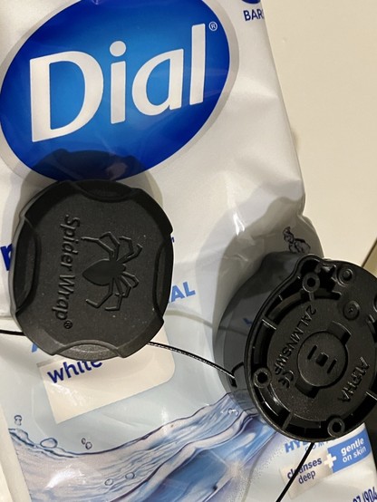A package of Dial soap bars with a Spider Wrap anti-theft device wrapped around it. A wire on the device has been cut.