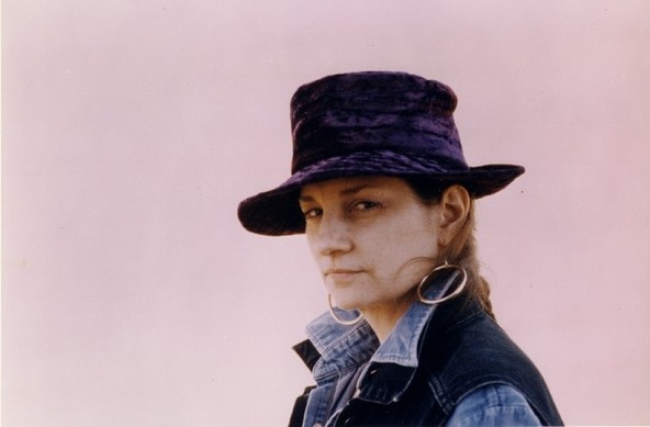 A color photo of Marian Zazeela wearing her signature purple felt hat and denim jackets.