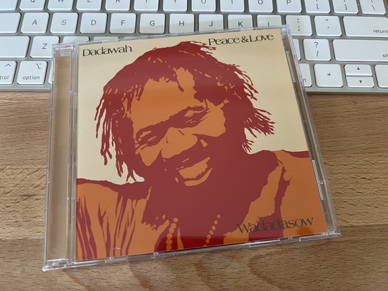 A photo of the album cover for this CD has a thresholded effect on the image of a smiling Ras Michael. The parts that would be black are brick red, while the white space is burnt orange.