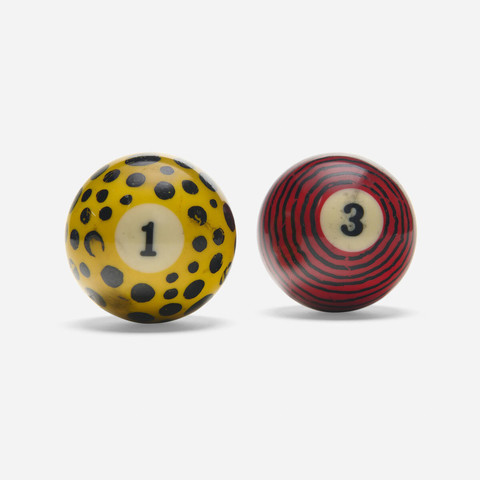 A color photo of two pool balls painted by Jason: a yellow 1 ball with black polka dots and a red 3 ball black stripes.