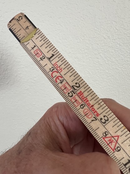 A color photo of said folding ruler looking at it from the top. It has markings in inches and centimeters and can open to a very impressive length of about 33.5 inches or 85 centimeters.