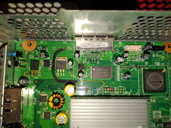 Inside view of an XBox 360 console. There are a few aftermarket modifications consisting of a few wires and some shrink-wrapped components.