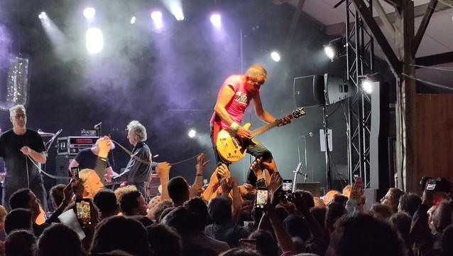 Didier Wampas joue de la guitare porté par la foule lors d'un concert en Bretagne