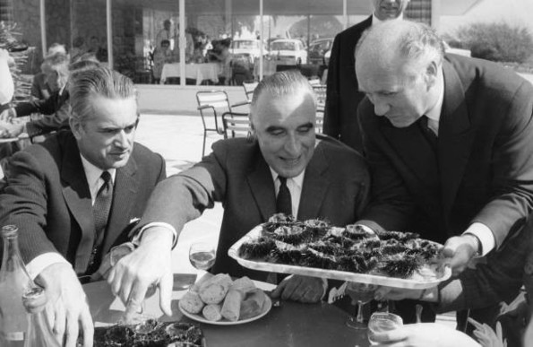 Attablé en extérieur avec Jacques Chaban-Delmas, Georges Pompidou se fait présenter un plateau d'oursins qu'il contemple avec un grand sourire.