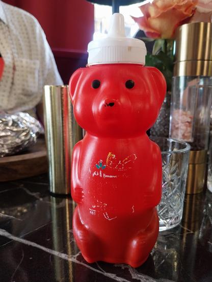 Bear-shaped ketchup bottle on a set table 