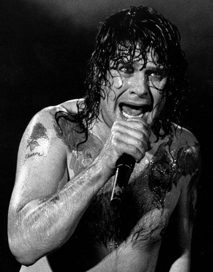 Black-and-white photo of Ozzy topless and drenched in sweat while performing live.