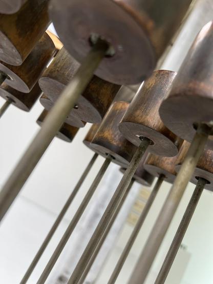 Untitled Sonambient instrument/sculpture made from beryllium copper and aluminum on brass plate with 16 rods in a tight 4 × 4 layout. There are mallet-like caps on each rod, each are slightly different heights.