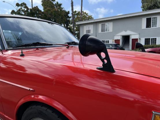 Up close detail of the hood-mounted side view mirror. Looks aftermarket, but who cares.