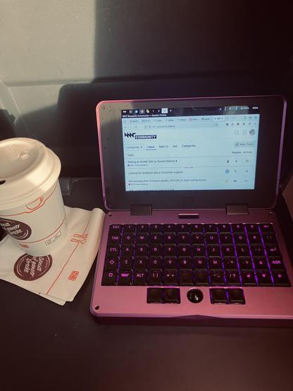 Purple MNT Pocket Reform next to a Deutsche Bahn coffee cup 