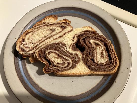 A slice of povitica, a traditional Eastern European sweet bread filled with cocoa and nuts. It resembles the shape of a rabbit.
