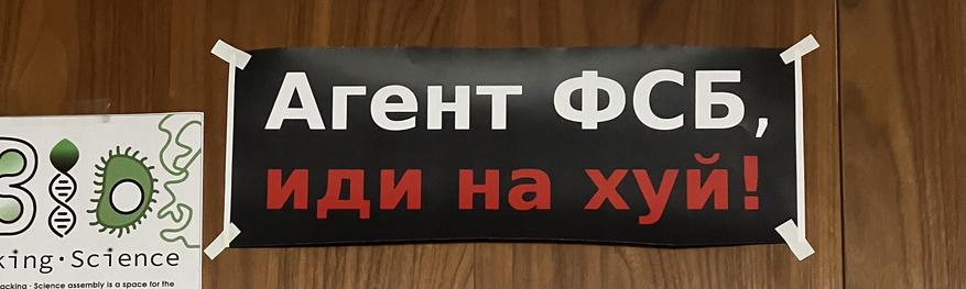 A sign that says „Агент ФСБ, иди на хуй!“ (FSB agent, fuck off!)