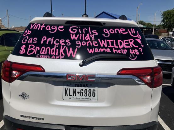 The rear end of a white GMC Acadia. Written on the window in pink temporary paint: “Vintage Girls Gone Wild! Gas Prices gone WILDER! Wanna help us? $BrandiKW cash app”

This vehicle was parked in a very busy public space, I’m not blurring any PII because presumably they intend it to be seen.