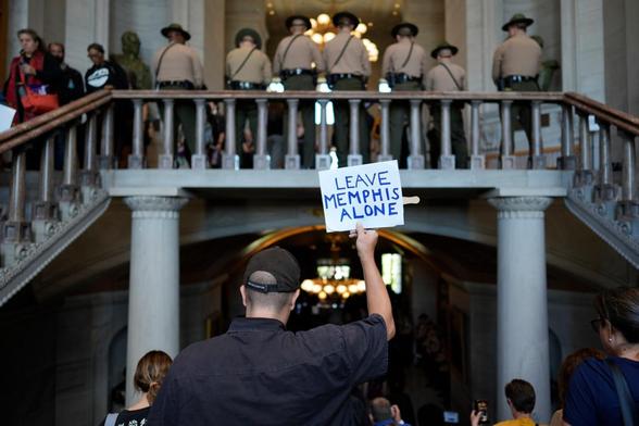 After Tennessee Republicans in the state legislature voted to strip Congressional representation from Memphis, Tennessee, I am seen descending the staircase from the House and Senate chambers to the exit at the state capitol in Nashville. The photo is taken from behind me, so my back is to the camera. I’m dressed in all black and holding a sign that says “Leave Memphis Alone.” Above me, THP troopers line the balcony.

Original caption: A person leaves the state Capitol after a special session o…