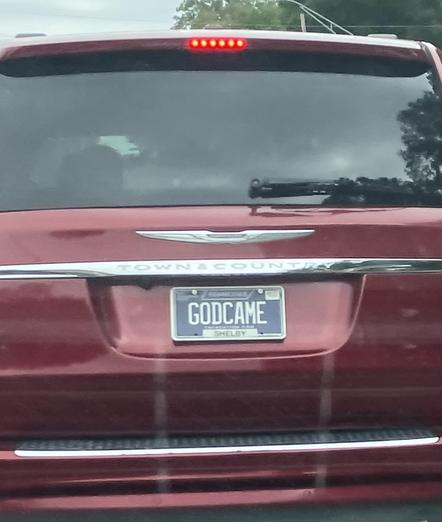 A maroon Chrysler Town & Country bearingTennessee vanity tag “GODCAME”