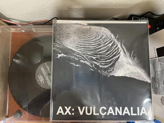 Record spinning on the turntable and the album cover visible on top.