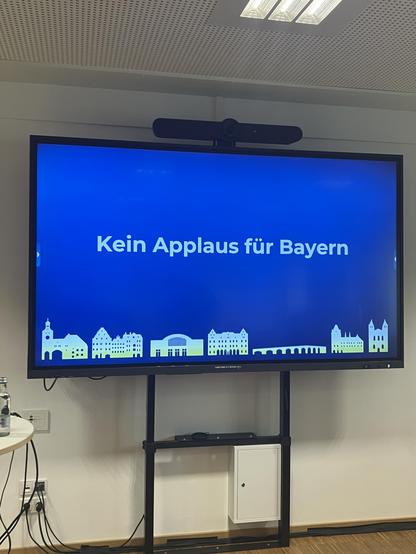 Vortragsfolie mit der Aufschrift „Kein Applaus für Bayern“